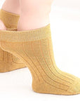 Mustard yellow cotton socks worn by child showing ribbed knit design and flexible fit.
