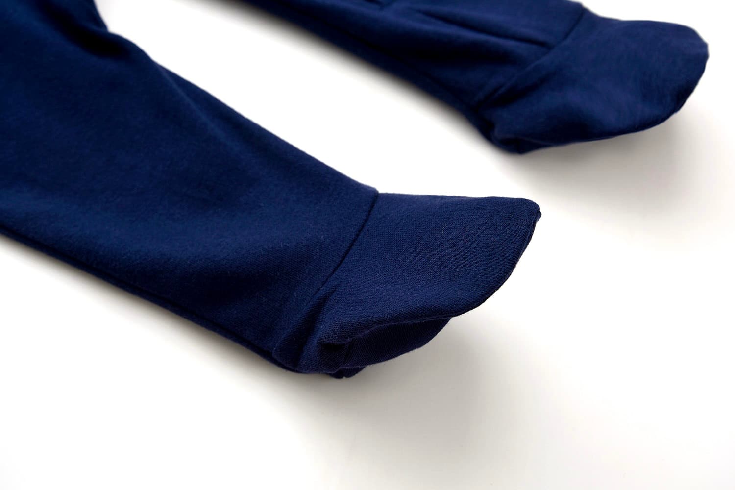 Close-up of navy blue cotton baby romper showing round neckline and zipper finish.
