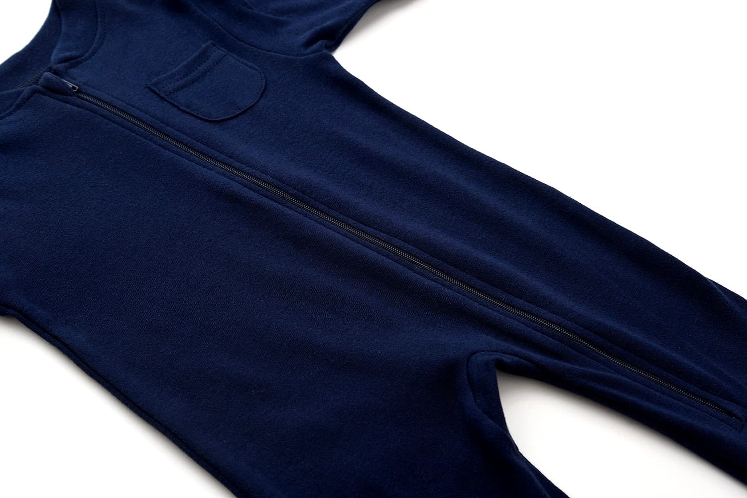 Close-up of navy blue cotton baby romper showing front zipper and soft fabric texture.