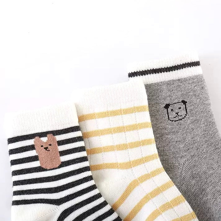 Close-up of striped cotton baby socks in grey and cream tones
