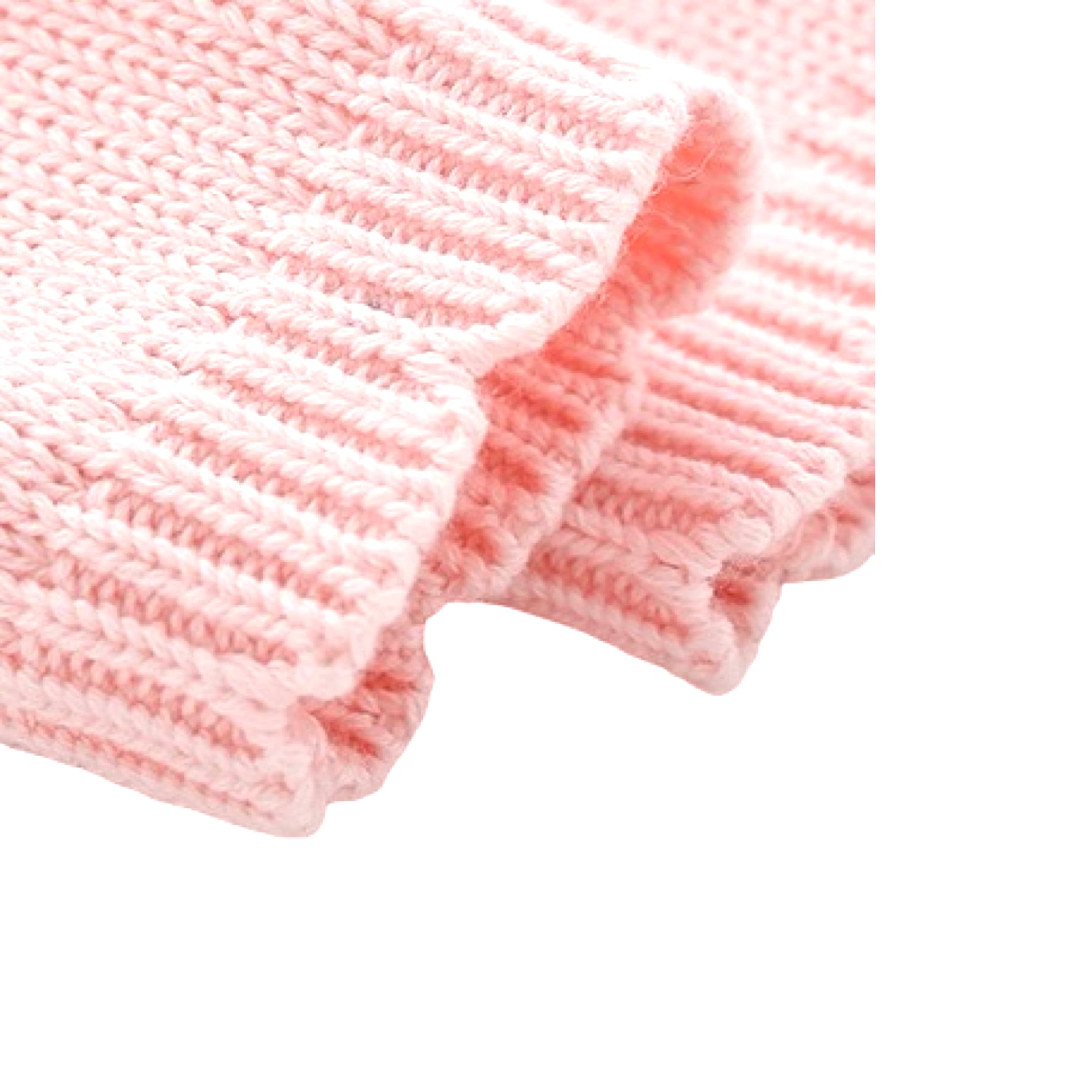 Close-up of soft ribbed cuff detail on pink knit baby romper made from cotton.
