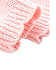 Close-up of soft ribbed cuff detail on pink knit baby romper made from cotton.
