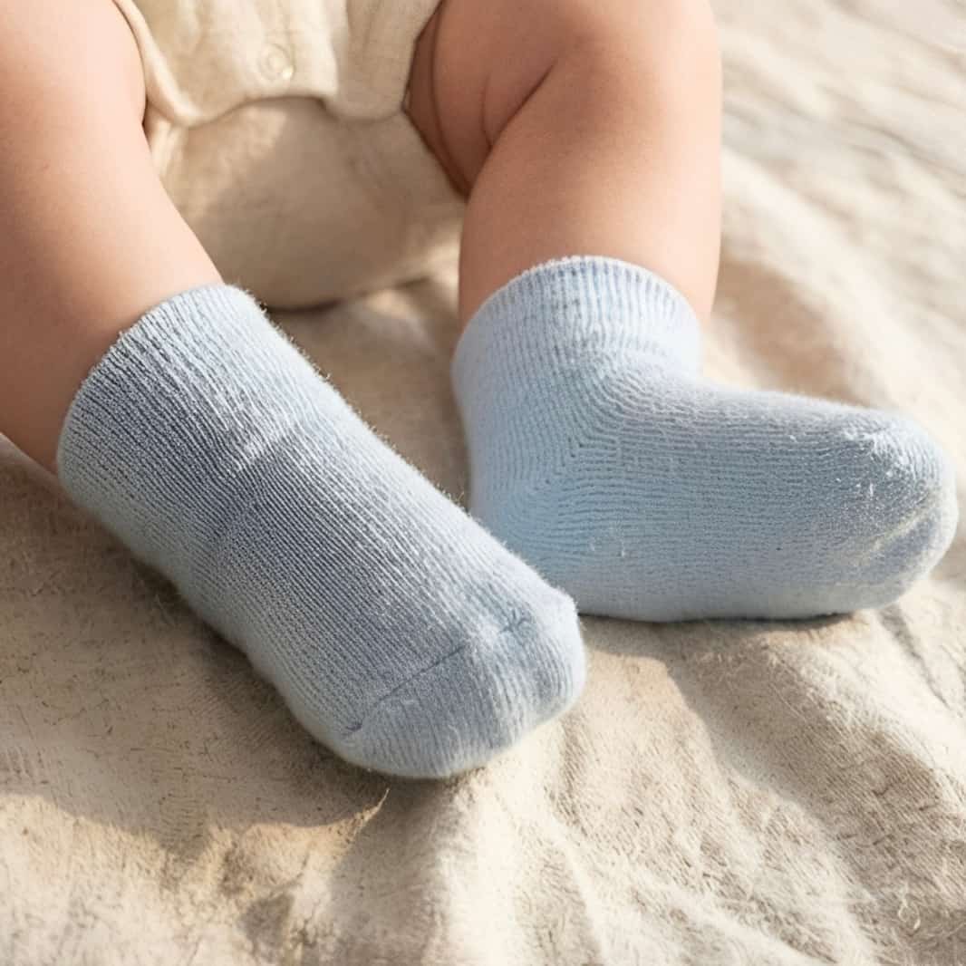 Baby wearing light blue cotton crew socks on feet, soft and breathable fabric