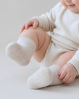 baby wearing beige ribbed cotton anti-slip socks with soft grip soles for newborns and toddlers