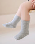 Person wearing gray socks on a light background