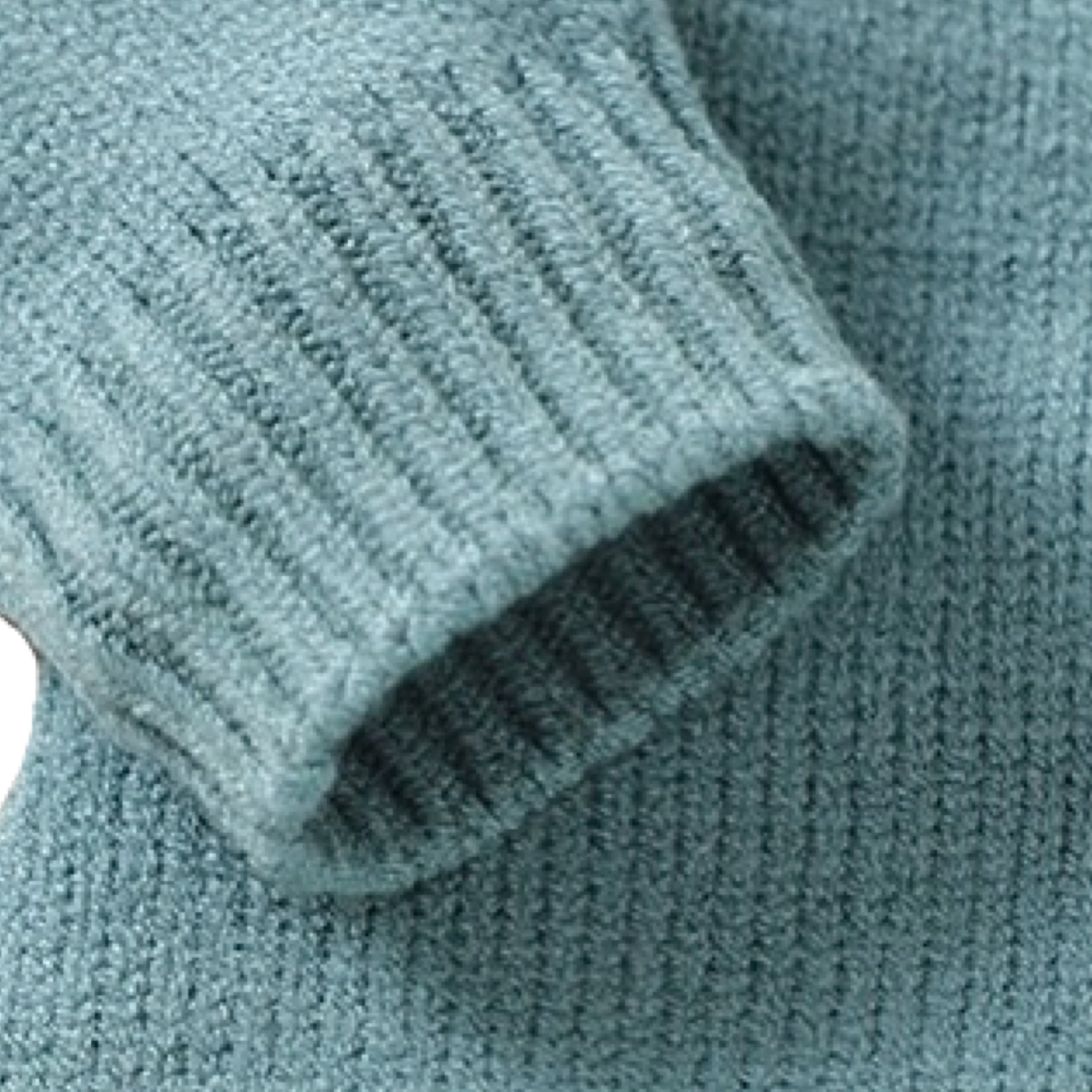 Detailed view of sleeve cuff on blue-green knitted baby romper highlighting soft stretch knit texture.
