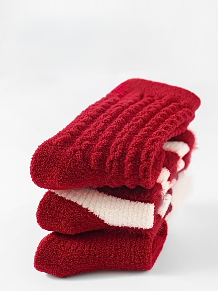 Stack of thick red baby socks showcasing cozy thermal material and premium winter warmth for infants.