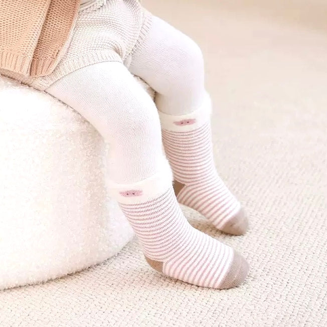 Baby model wearing striped bear baby socks – neutral tones and soft cotton design