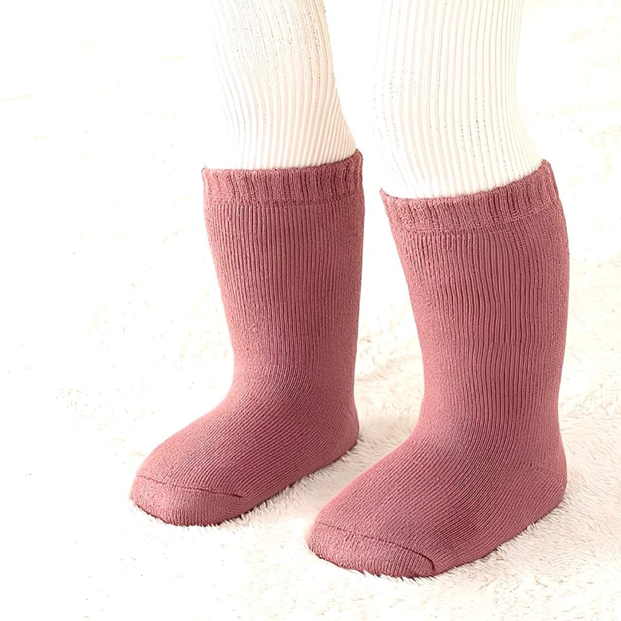 Toddler standing in thick pink cotton socks, cozy and breathable winter wear
