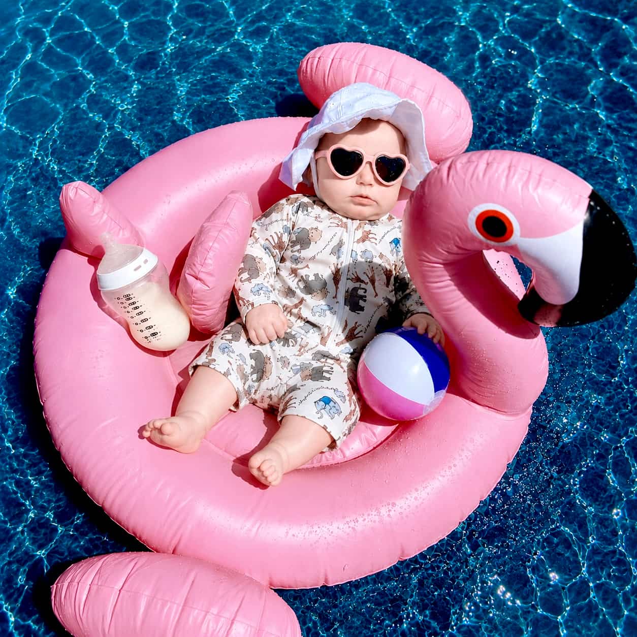 toddler wearing animal print rash guard swimsuit playing with sand at the beach UV swimwear