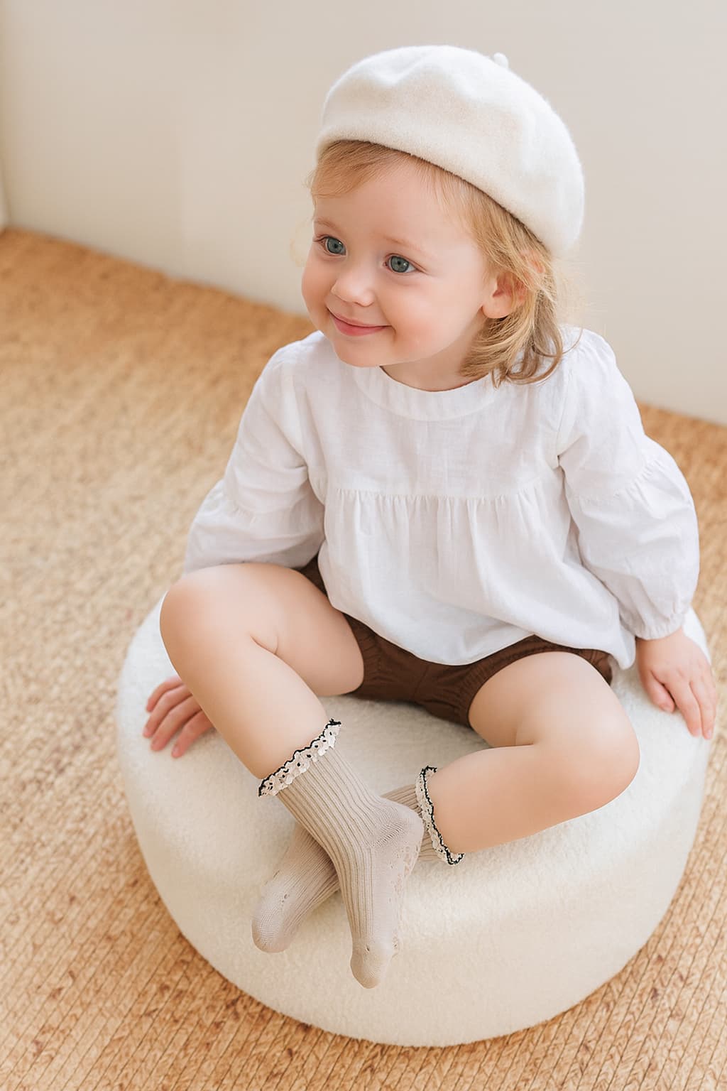 Toddler wearing beige cotton ruffle socks, matching neutral fall outfit