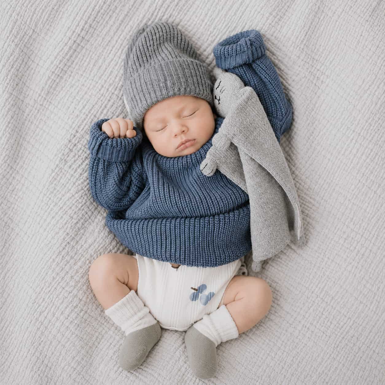 Newborn baby wearing two-tone winter knit baby socks in soft neutral cotton colours with cosy minimalist baby outfit