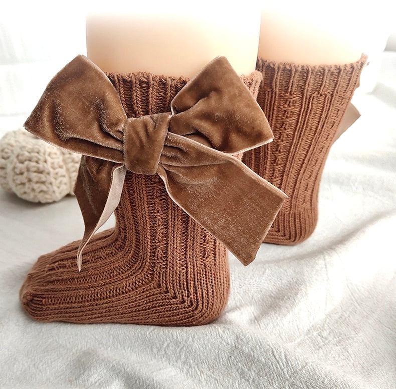 Baby wearing brown velvet bow socks — cozy, stylish cotton baby socks for all seasons.

