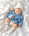 Baby wearing striped cable knit baby socks in soft cotton with cosy neutral winter baby outfit and minimalist nursery style