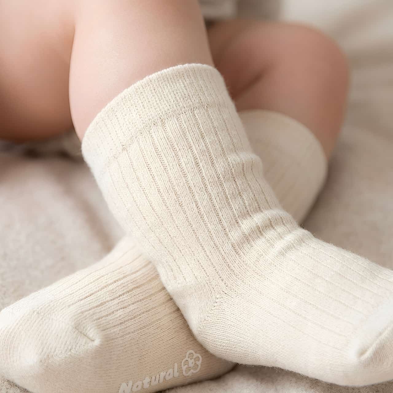 Close-up of baby wearing soft cotton socks in warm neutral color