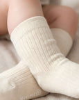 Close-up of baby wearing soft cotton socks in warm neutral color