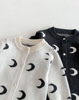 White and dark gray cotton baby rompers side by side – moon pattern unisex jumpsuits.

