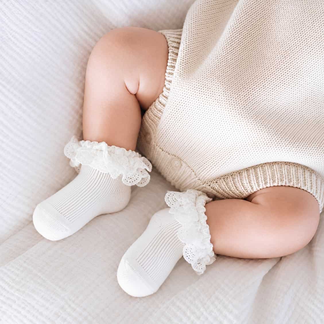 Baby wearing white floral bow cotton socks with delicate lace trim and soft breathable comfort for baby girls and toddlers