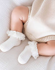 Baby wearing white floral bow cotton socks with delicate lace trim and soft breathable comfort for baby girls and toddlers
